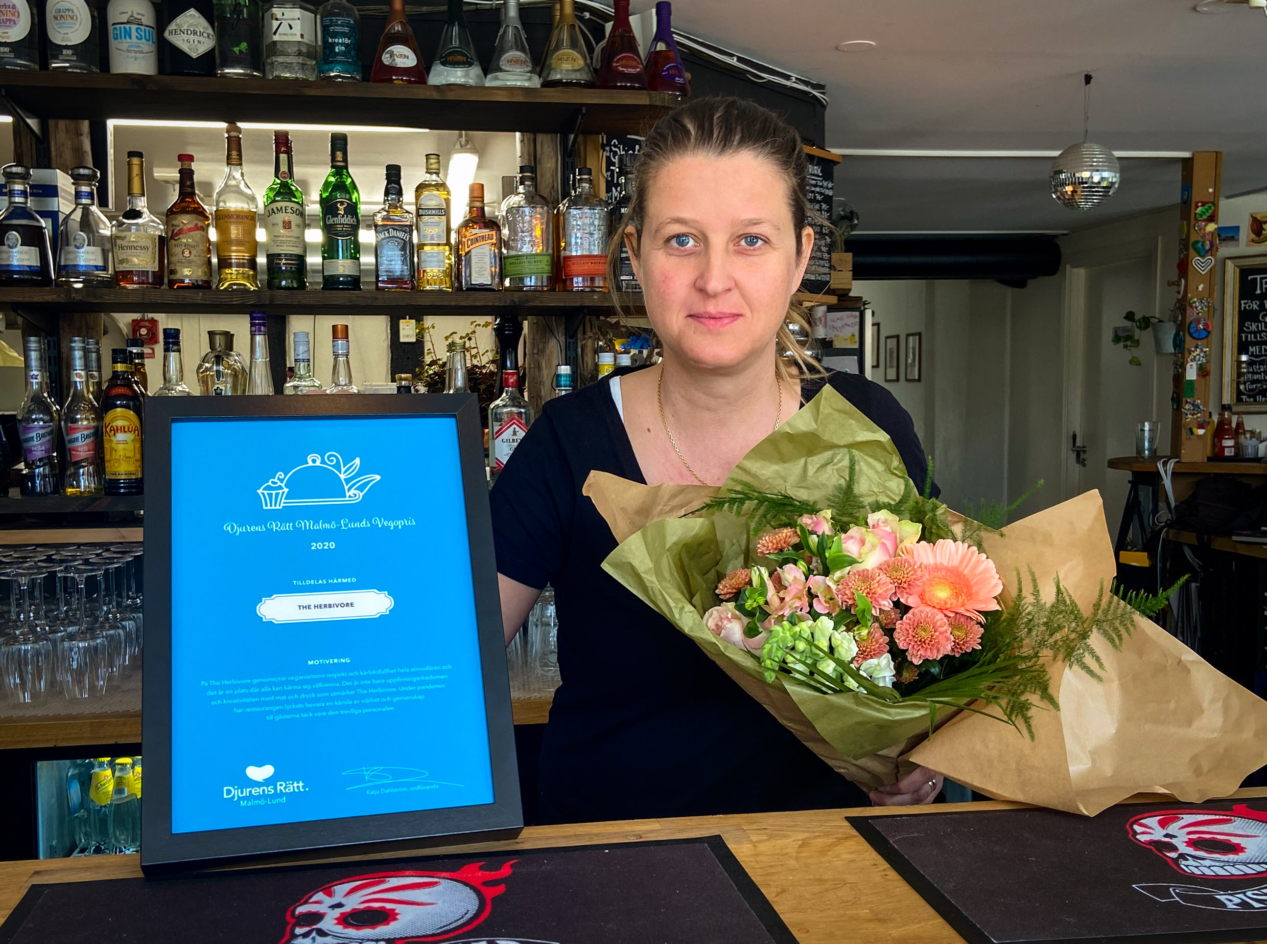 Foto på Camilla von Haartman från The Herbivore, hållande en bukett blommor och vårt inramade vegopris